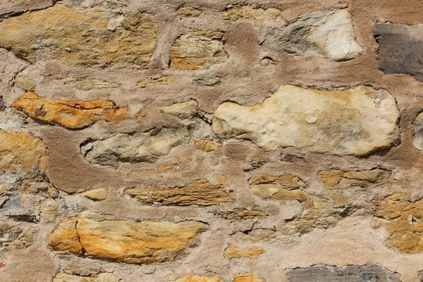 Natural background, ancient wall of the medieval city, the wall of an ancient temple in Prague, stone masonry test with cement