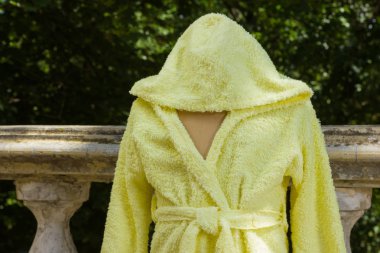 Bornoz havlu kumaş bir manken üzerinde üzerinden. Çocuk bornoz kukuleta ile çocuklar için sarı. Çocuk el yapımı giyim İtalyan terry bezle. Nemi emer saçak ile ev giyim