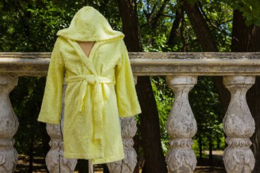 Bornoz havlu kumaş bir manken üzerinde üzerinden. Çocuk bornoz kukuleta ile çocuklar için sarı. Çocuk el yapımı giyim İtalyan terry bezle. Nemi emer saçak ile ev giyim