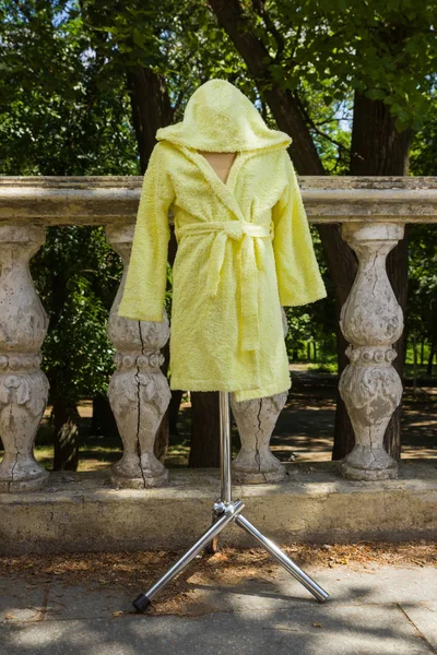 Bornoz havlu kumaş bir manken üzerinde üzerinden. Çocuk bornoz kukuleta ile çocuklar için sarı. Çocuk el yapımı giyim İtalyan terry bezle. Nemi emer saçak ile ev giyim