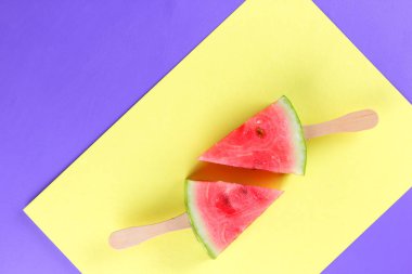 Karpuz pop art. Karpuz Stick sarı mor arka plan üzerinde parçaları. Doğal tatlı minimalist tarzda. Vegan gıda ile yaratıcı hikaye