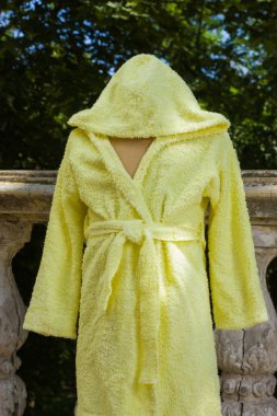 Bornoz havlu kumaş manken üzerinde üzerinden. Çocuk bornoz kukuleta ile çocuklar için sarı. Çocuk el yapımı giyim İtalyan terry bezle. Nemi emer saçak ile ev giyim