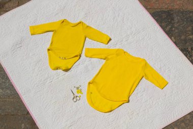 Çocuk giyerlerdi. Sarı bebek elbise hafif bir arka plan el yapımı. Dikiş elbise. Makas ve doğal kumaş. Kopya alanı