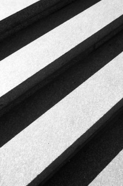 Merdiven basamakları kapatın. Siyah ve beyaz arka planda minimalist tarzı. Işık ve gölge simetrik çizgileri. Adımlar arka plan