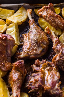 Patates ile pişmiş et. Et sac pişirme üzerinde altın kabuk ile ördek. Fırın çanak parşömen üzerine pişmiş. Tavuk eti ile altın dilimlenmiş patates. Ev mutfak