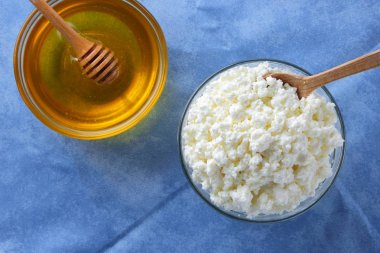 Süzme peynir. Süzme peynir ve bal mavi peçete üzerinde. Züccaciye Mağazaları suda peynir. Kahvaltıda süt ürünleri. Kopya alanı