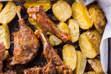 Patates ile pişmiş et. Et sac pişirme üzerinde altın kabuk ile ördek. Fırın çanak parşömen üzerine pişmiş. Tavuk eti ile altın dilimlenmiş patates. Ev mutfak