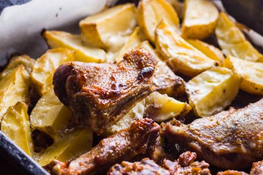 Patates ile pişmiş et. Et sac pişirme üzerinde altın kabuk ile ördek. Fırın çanak parşömen üzerine pişmiş. Tavuk eti ile altın dilimlenmiş patates. Ev mutfak