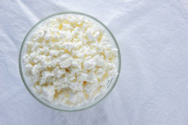 Süzme peynir. Beyaz arka plan üzerinde süzme peynir. Cam beyaz peçete üzerinde suda peynir. Kahvaltıda süt ürünleri. Kopya alanı