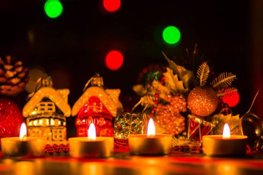 Neşeli Noel. Oyuncak ev ve mum ışığı. Noel süslemeleri üzerinde arka plan bulanık. Festival akşam. Çam dalları ve Noel oyuncaklar bokeh ile. Kopya alanı