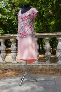 Manken üzerinde kadın bluzu. Yazlık bluz tüyler deseni ile doğal kumaş ile. Kadın giyim yeşil ağaçlar arka plan üzerinde