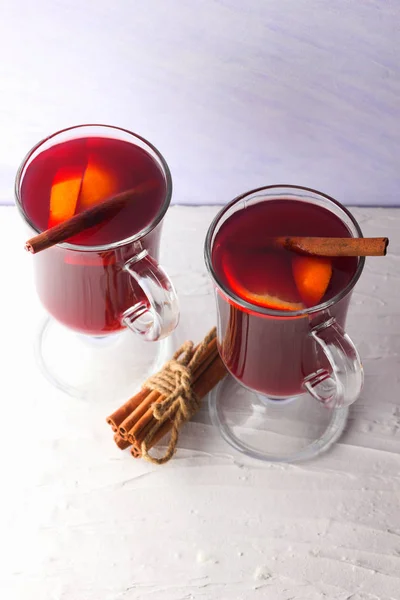 Mulled wine on white background. Christmas mulled wine, cinnamon sticks, anise and honey. Alcoholic drink of wine, fruit and honey. Festive drink and Christmas tree branches