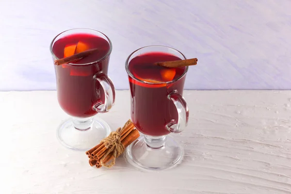 Mulled wine on white background. Christmas mulled wine, cinnamon sticks, anise and honey. Alcoholic drink of wine, fruit and honey. Festive drink and Christmas tree branches