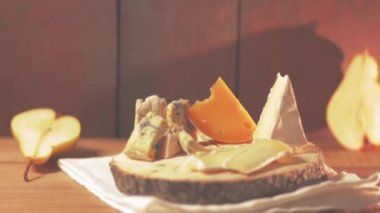 Peynir ve armut ahşap kurullarında parçaları çeşitli türü. Mavi peynir, camembert ve ahşap stand sert peynir. Peynir ve olgun armut