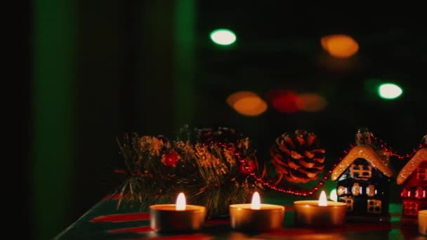 云杉树枝和圣诞玩具与 Bokeh 圣诞快乐玩具屋和烛光 模糊背景上的圣诞装饰品 节日晚会 — 图库视频影像