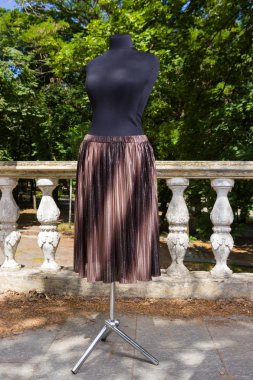 Kahverengi etek manken üzerinde. Doğal zemin üzerine modülasyon ile etek. Pullu kumaş kadın giyim için. Terzilik birey