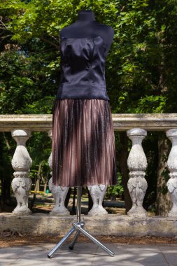 Kahverengi etek ve siyah korse manken üzerinde. Etek ve korse ile doğal zemin üzerine modülasyon. Pullu kadın giyim için kumaş. Terzilik birey