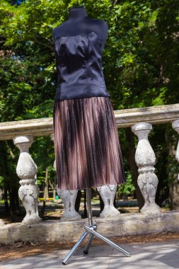 Kahverengi etek ve siyah korse manken üzerinde. Etek ve korse ile doğal zemin üzerine modülasyon. Pullu kadın giyim için kumaş. Terzilik birey