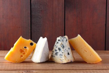 Peynirler ahşap kurullarında farklı türleri. Camembert, sert sarı peynir, dorblu ahşap kurullarında. Kopya alanı