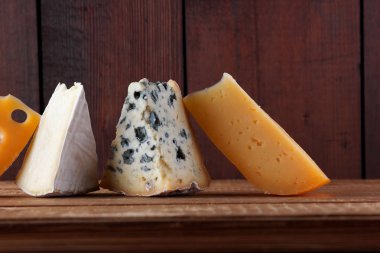 Peynirler ahşap kurullarında farklı türleri. Camembert, sert sarı peynir, dorblu ahşap kurullarında. Kopya alanı