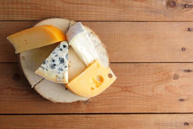 Peynirler ahşap kurullarında ürün yelpazesine. Camembert, sert sarı peynir, dorblu ahşap stand. Üstten görünüm