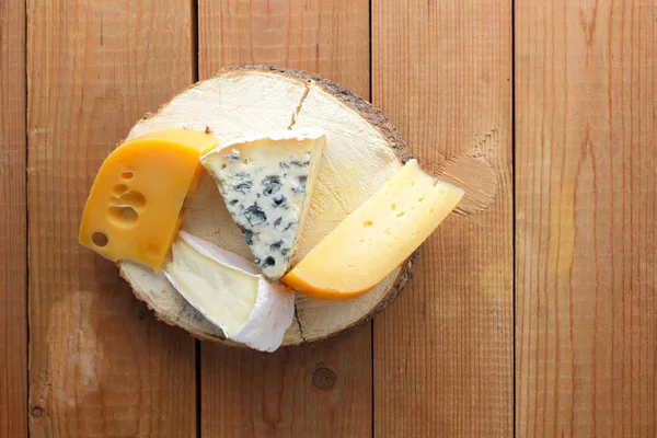 Peynirler ahşap kurullarında ürün yelpazesine. Camembert, sert sarı peynir, dorblu ahşap stand. Üstten görünüm
