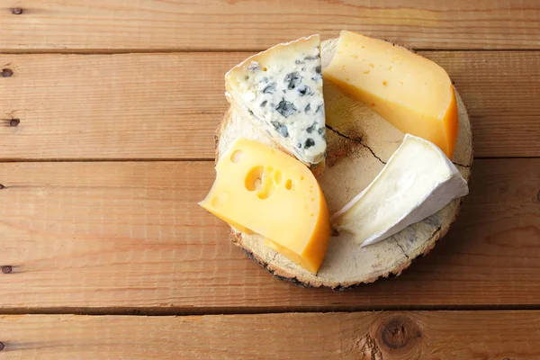 Peynirler ahşap kurullarında ürün yelpazesine. Camembert, sert sarı peynir, dorblu ahşap stand. Üstten görünüm