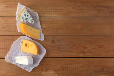 Peynir ahşap kurullarında türleri. Camembert, sert sarı peynir, parşömen kağıt üzerinde dorblu. Üstten görünüm