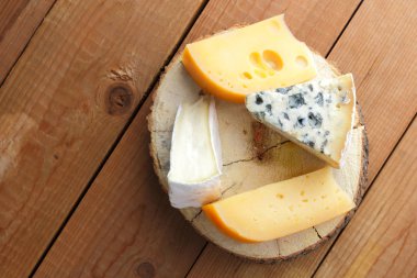 Peynir ahşap kurullarında. Camembert, sert sarı peynir, dorblu ahşap stand. Üstten görünüm