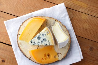 Peynir beyaz kumaş üzerine çeşitli türleri. Camembert, sert sarı peynir, dorblu ahşap kurullarında. Süt ürünleri Beyaz peçete üzerinde. Kopya alanı