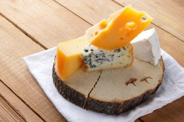 Beyaz bez üzerine peynir. Camembert, sert sarı peynir, tahta tahtalar üzerinde dorblu. Beyaz peçete de süt ürünleri. Kopyalama alanı