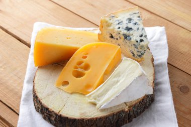 Beyaz bez üzerine peynir. Camembert, sert sarı peynir, tahta tahtalar üzerinde dorblu. Beyaz peçete de süt ürünleri. Kopyalama alanı