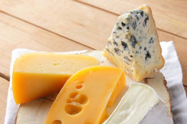 Beyaz bez üzerine peynir. Camembert, sert sarı peynir, tahta tahtalar üzerinde dorblu. Beyaz peçete de süt ürünleri. Kopyalama alanı