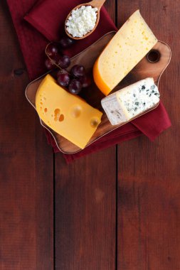 Sert peynir, mavi peynir ve peynir bir ahşap tahta üzerinde. Peynir kırmızı peçeteye farklı türleri. Süt ürünleri ve limon ahşap arka plan üzerinde. Üstten görünüm