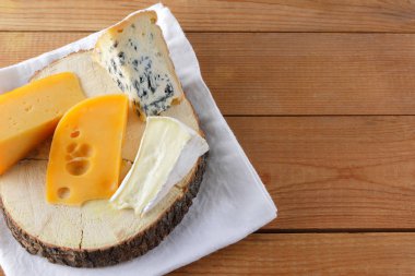 Beyaz kumaş üzerine peynir. Camembert, sert sarı peynir, dorblu ahşap kurullarında. Süt ürünleri Beyaz peçete üzerinde