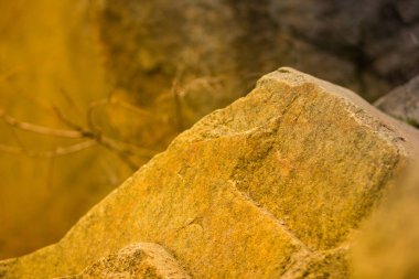Turuncu tonlama olarak Granit kayalar. Granit kapatın. Sarı renk ile Taş dokusu. Sıcak renkler doğal malzemeden arka plan