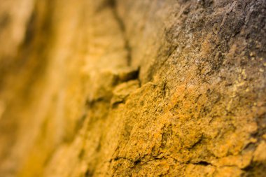 Turuncu tonlama olarak Granit kayalar. Granit kapatın. Sarı renk ile Taş dokusu. Sıcak renkler doğal malzemeden arka plan