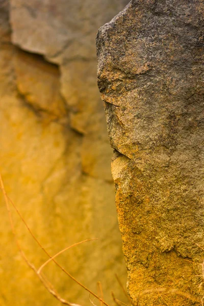 Granite rocks in orange toning. Granite close up. Texture of the stone with yellow color. Background from natural material with warm colors