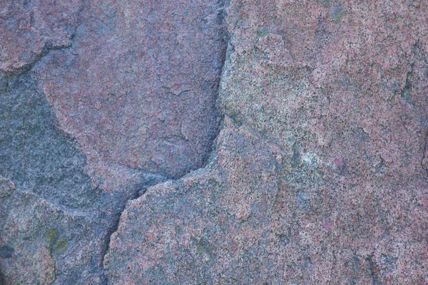 Texture of granite close up. Granite rock with reddish color. Background from solid stone. Pattern with natural material