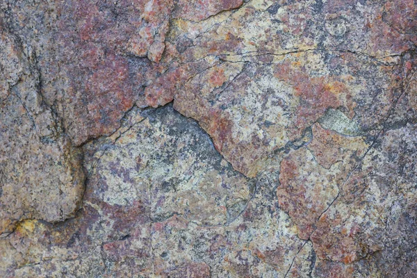 Texture of granite close up. Granite rock with reddish color. Background from solid stone. Pattern with natural material