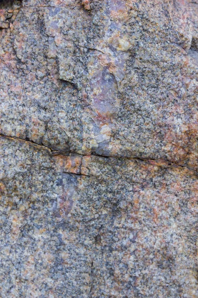 Granite texture close up. Granite rocks with porous surface. Background from solid stone. Pattern with natural material