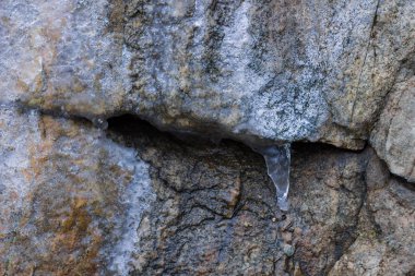 Buz sarkıtları Granit kayalar üzerinde. Donmuş su taş. Kışın temiz su. Dağlarda tatlı su kaynağı