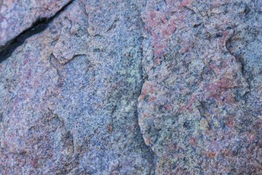 Granit dokusuna yakın çekim. Kırmızımsı renkli granit kaya. Sağlam taş kökenli. Doğal malzeme ile desen