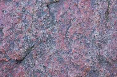 Granit dokusuna yakın çekim. Kırmızımsı renkli granit kaya. Sağlam taş kökenli. Doğal malzeme ile desen