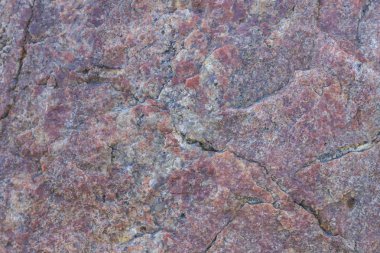 Granit dokusuna yakın çekim. Kırmızımsı renkli granit kaya. Sağlam taş kökenli. Doğal malzeme ile desen