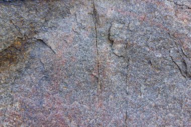 Granit dokusuna yakın çekim. Kırmızımsı renkli granit kaya. Sağlam taş kökenli. Doğal malzeme ile desen