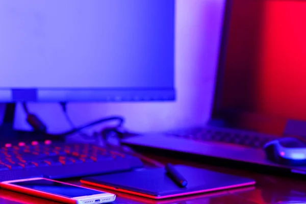 職場デジタル デザイナー ネオンの光でフリーランサー職場 コンピューター グラフィックス タブレット スマート フォン テーブルの上 ブルー — ストック写真