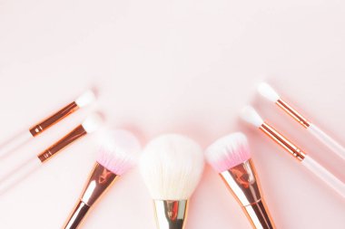 Makyaj pembe arka plan fırçalar. Altın makyaj fırçaları, dizi kavramı. Kadın güzellik Aksesuar pastel renklerde. Uzay kopyalayın. Düz yatıyordu