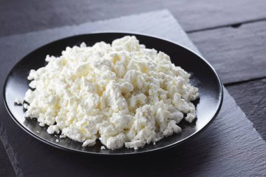 Süzme peynir siyah arduvaz gemide. Peynir siyah plaka üzerinde. Yumuşak peynir diyet siyah panoları için. Kahvaltı için sağlıklı süt ürünleri. Kavramı