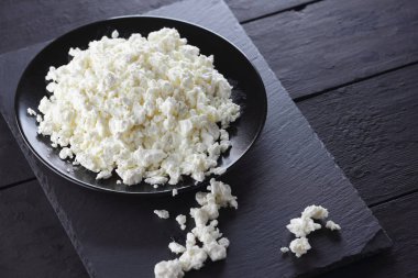 Süzme peynir siyah arduvaz gemide. Peynir siyah plaka üzerinde. Yumuşak peynir diyet siyah panoları için. Kahvaltı için sağlıklı süt ürünleri. Kavramı